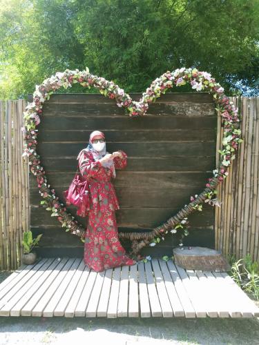a woman in a mask standing in front of a heart at Homestay Damai Sri Kota in Kepala Batas