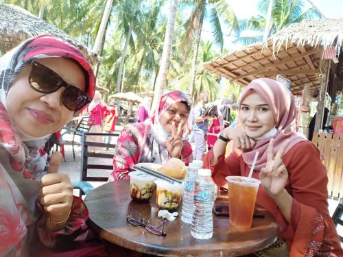 a group of three women sitting at a table at Homestay Damai Sri Kota in Kepala Batas