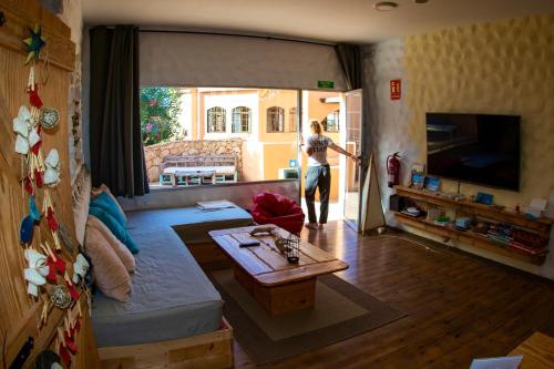 a woman opening the door to a living room at Wellenkind Surfschool in La Pared