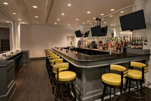 a bar with yellow stools in a restaurant at Crowne Plaza Englewood, an IHG Hotel in Englewood
