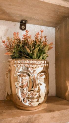 a large silver vase with a plant in it at Casinha Astral - Praia da Ferrugem in Garopaba