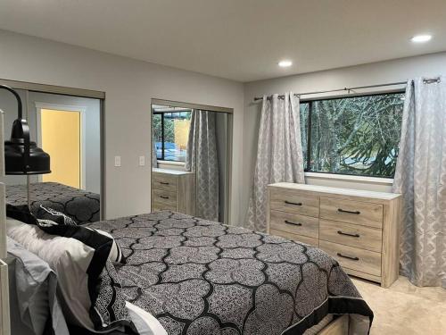 a bedroom with a large bed and a window at Country Living in the City. in Campbell River