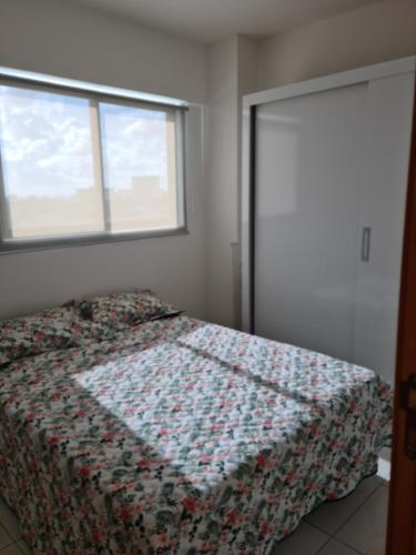 um quarto com uma cama com uma colcha em Flat próximo à UFPE no Recife