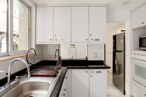 a white kitchen with a sink and a refrigerator at Experience México City Condesa, Central Location, Rooftop Terrace, Coworking, Amazing Artistic Place in Mexico City