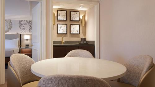 a white table and chairs in a room with a bed at Caesars Atlantic City Hotel & Casino in Atlantic City