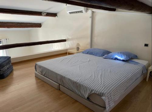 a bedroom with a large bed with blue pillows at L'AUTHENTIQUE - Sur le Port - Parking - Wifi in Cassis