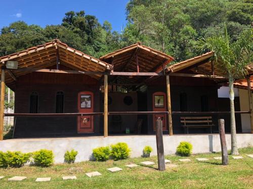 Un edificio con un banco delante de él. en POUSADA HARAS K&k, en Pinhalzinho