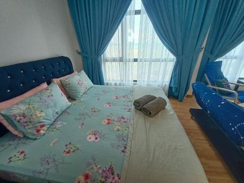 クアンタンにあるImperium Residence Tanjung Lumpur SEAVIEW Studio Hafizのベッドルーム1室(ブルーヘッドボード付きのベッド1台付)