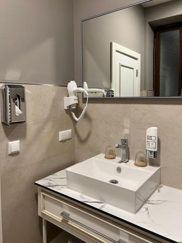 a bathroom with a white sink and a mirror at The Kepos Hotel Erlangen in Erlangen