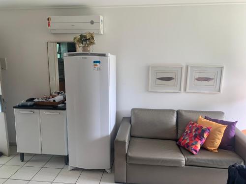 a living room with a couch and a white refrigerator at Flat Beach Class Resort Muro Alto in Porto De Galinhas