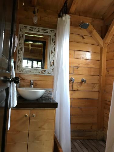 y baño con lavabo y espejo. en Acogedora cabaña de madera en la naturaleza para desconectarse, en Sogamoso