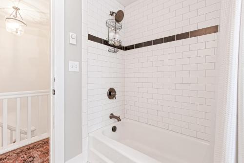 a white bath tub in a bathroom with white tiles at Blue Moose Downtown Home in Sandpoint