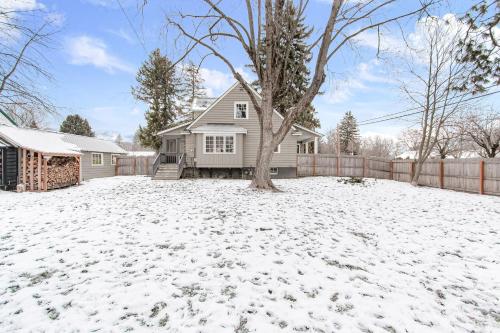 a house with a tree in the snow at Blue Moose Downtown Home in Sandpoint