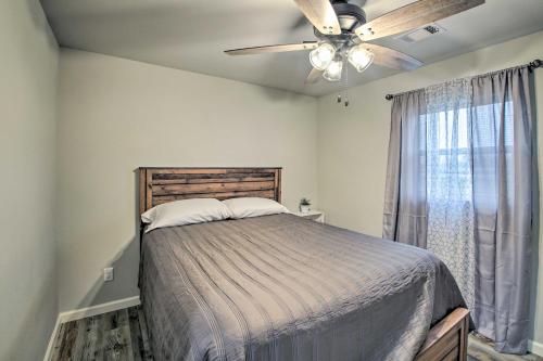 Schlafzimmer mit einem Bett, einem Deckenventilator und einem Fenster in der Unterkunft Bright Cabin with Spacious Deck and Fire Pit! in Royal