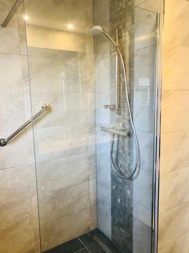 a shower with a glass door in a bathroom at Strand Villa Stern Noordwijk in Noordwijk