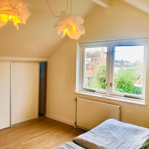 a bedroom with a window and a bed in it at Strand Villa Stern Noordwijk in Noordwijk