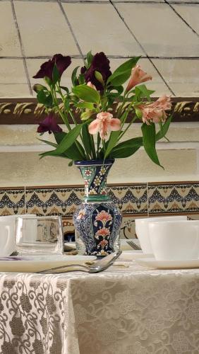 um vaso azul e branco com flores sobre uma mesa em HOTEL SHAHDIL em Samarkand