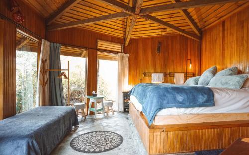a bedroom with two beds in a room with wooden walls at Ora Retreat in Queenstown