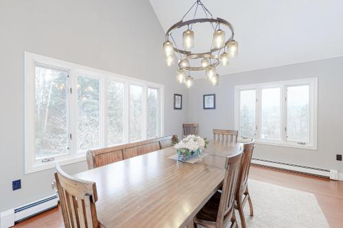 a dining room with a wooden table and a chandelier at Campton White Mountains Retreat in Campton