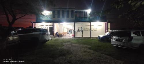 a building with cars parked in front of it at night at penginapan karanglaut santolo in Cilauteureun