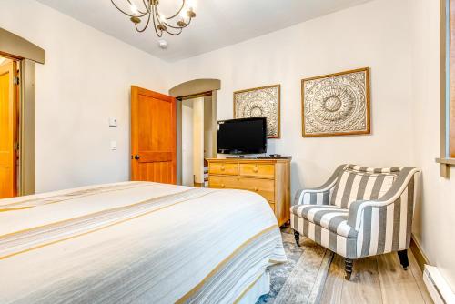 a bedroom with a bed and a tv and a chair at Honeycomb House in Solitude