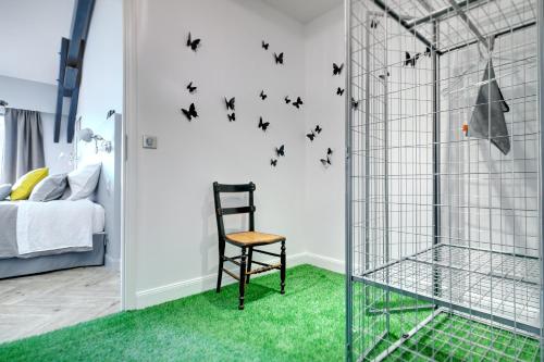 a room with a chair and black butterflies on the wall at Le Florida Auberge contemporaine in Castéra-Verduzan
