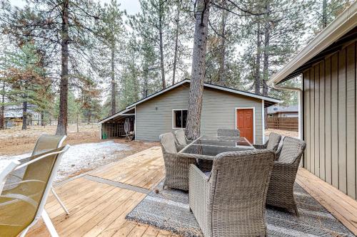 a patio with a table and chairs on a wooden deck at Retreat in the Pines in Sisters