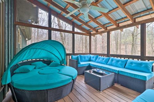 a screened in porch with blue furniture and a ceiling at Cozy Conyers Cabin with Fireplace and Pool Table! in Conyers