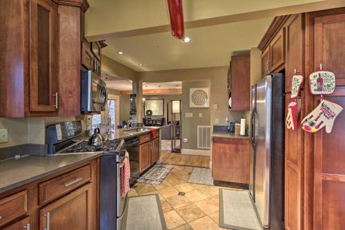 a kitchen with wooden cabinets and stainless steel appliances at Cozy Conyers Cabin with Fireplace and Pool Table! in Conyers
