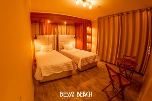 a bedroom with two beds and a table and chairs at Besso Beach Hotel in Barranca
