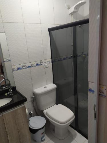 a bathroom with a toilet and a shower and a sink at Casa em Maragogi in Maragogi