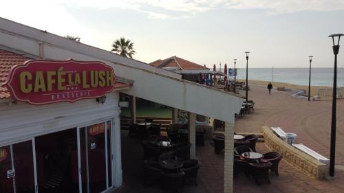a restaurant with a sign that reads caffeiniini on the beach at Breezot Yam in Nahariyya