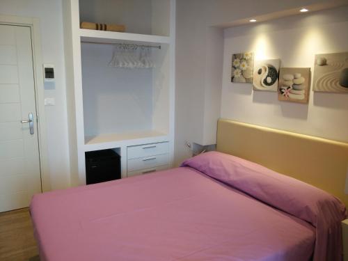 a bedroom with a pink bed and a window at Hotel l'Approdo in Porto Azzurro
