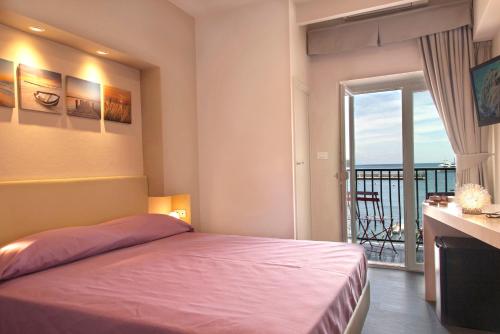a bedroom with a bed and a view of the ocean at Hotel l'Approdo in Porto Azzurro