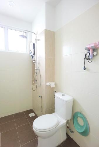 a bathroom with a white toilet and a shower at Desaru Kids Water Slide Private Pool & BBQ Homestay Bandar Penawar in Bandar Penawar
