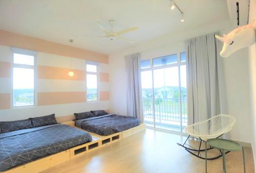 a bedroom with two beds and a balcony at Desaru Kids Water Slide Private Pool & BBQ Homestay Bandar Penawar in Bandar Penawar