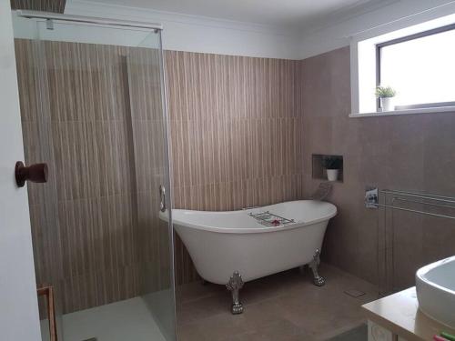 a bathroom with a bath tub and a sink at Spacious Holiday Home - Waikerie in Waikerie