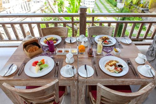 ein Holztisch mit Tellern voller Essen darauf in der Unterkunft Kawi Resort in Tegalalang