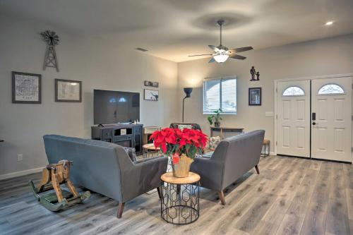 a living room with two couches and a table with red flowers at Stunning Clovis Home about 1 Mile to Old Town! in Clovis