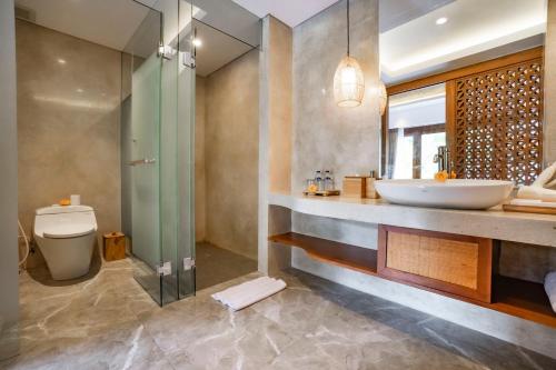 a bathroom with a sink and a toilet and a shower at Uma Shanti Villa by Mahaputra in Ubud