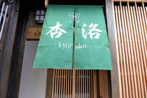 a green sign on the side of a building at JR京都駅徒歩10分。お風呂が素敵な貸切京町家。6人まで最適。 in Kyoto