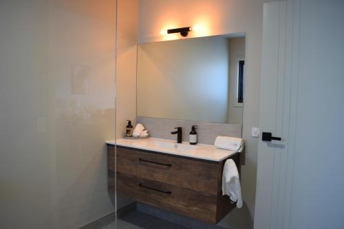 a bathroom with a sink and a mirror at The Top Place Retreat in Caveside