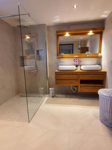 a bathroom with a shower and a sink and a mirror at LA VILLA ROSAYA - Piscine & Jacuzzi in Saint-Pierre