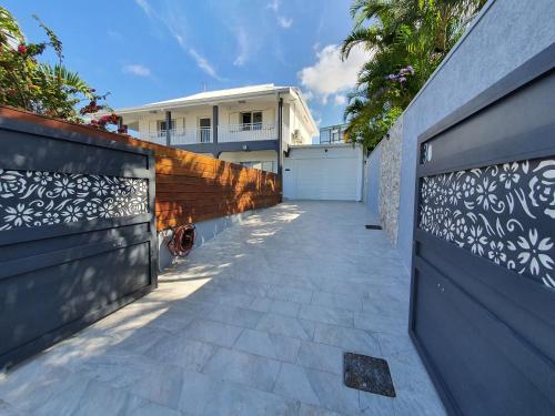 a driveway leading to a house with a fence at LA VILLA ROSAYA - Piscine & Jacuzzi in Saint-Pierre