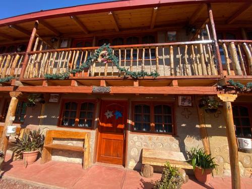 - un bâtiment en bois avec un balcon et une terrasse couverte dans l'établissement Cabañas Quinta San Agustin, à Zacatlán