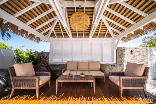 a patio with two couches and a table at LA VILLA ROSAYA - Piscine & Jacuzzi in Saint-Pierre