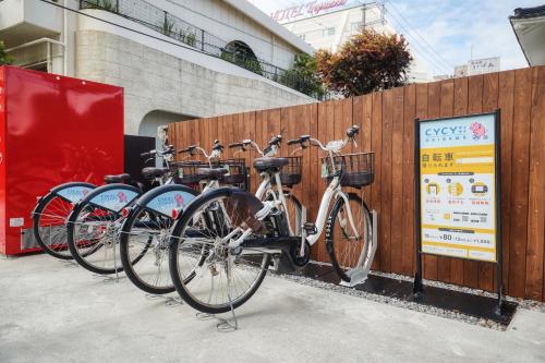 a row of bikes parked next to a fence at New Normal Hotel in NAMINOUE ニューノーマルホテルイン波の上 in Naha