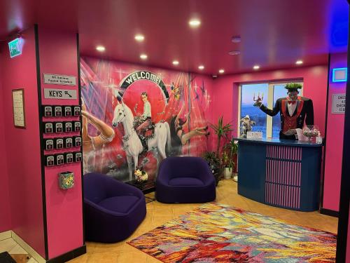 考納斯的住宿－Very Bad Hootel，一间粉红色墙壁的房间,上面有绘画作品