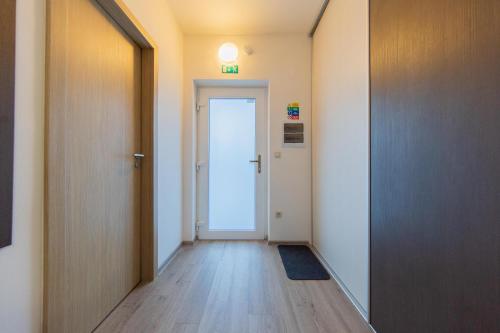un couloir vide avec une porte et un tapis de porte dans l'établissement Apartmán Sophia 4 s terasou, à Velké Losiny