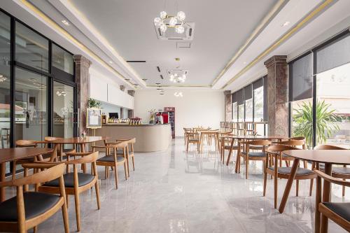 a restaurant with wooden tables and chairs and a counter at Vakara Hotel Kep in Kep